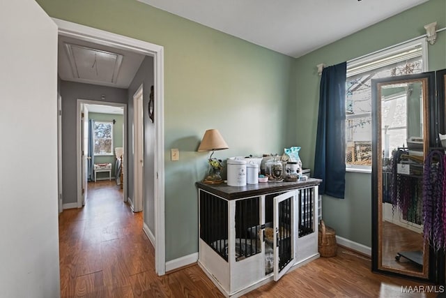 hallway with wood finished floors, attic access, and baseboards