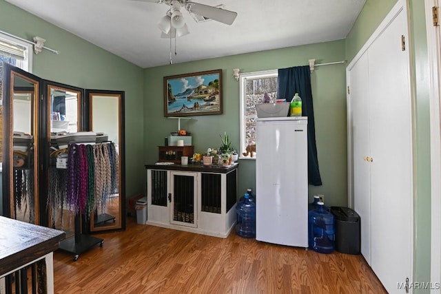 interior space featuring fridge, wood finished floors, and a ceiling fan