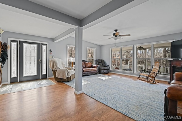 entrance foyer with vaulted ceiling with beams, light wood-style floors, and baseboards