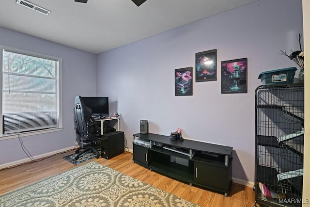 office space featuring baseboards, visible vents, and wood finished floors