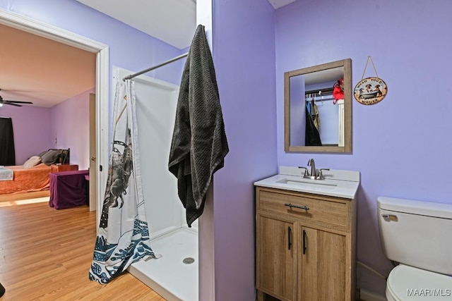 full bathroom featuring a stall shower, vanity, toilet, and wood finished floors