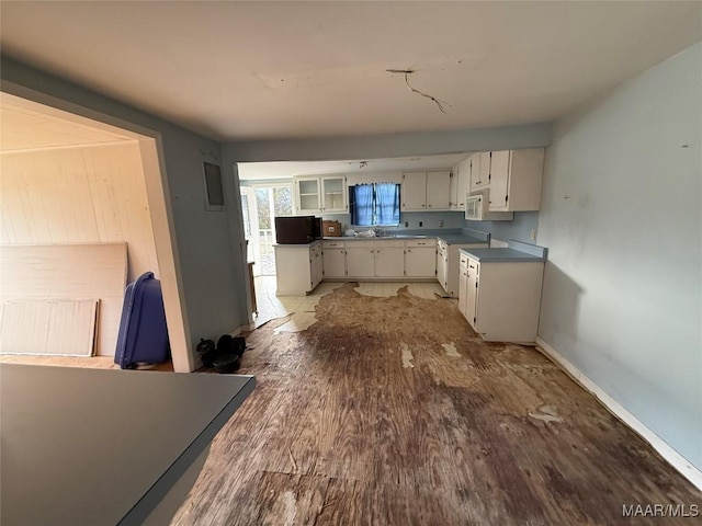 kitchen with white cabinetry, sink, wood-type flooring, and stove