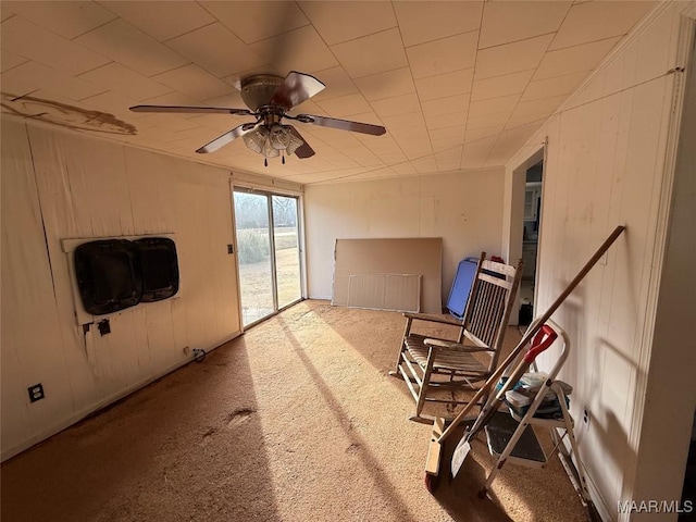 misc room with ceiling fan, carpet floors, and wood walls