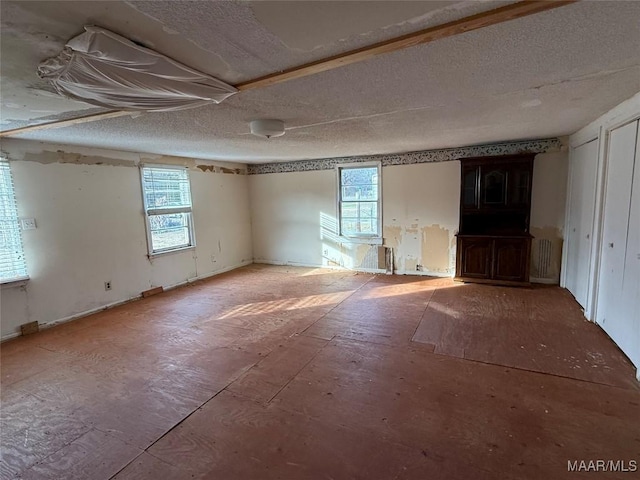 spare room featuring a healthy amount of sunlight and a textured ceiling