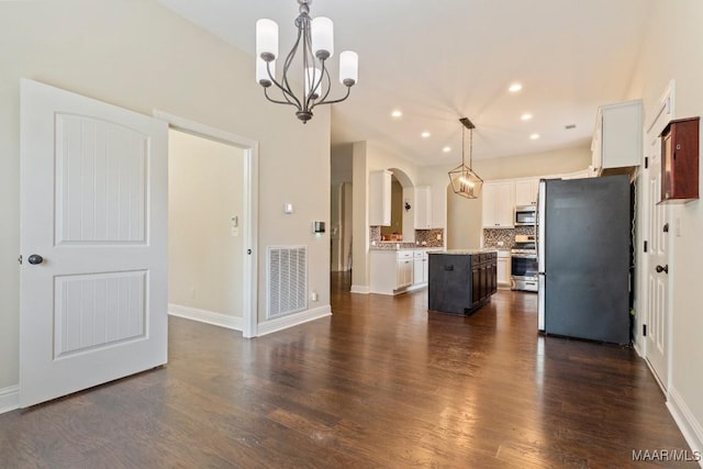 kitchen featuring white cabinets, visible vents, a chandelier, a kitchen island, and appliances with stainless steel finishes