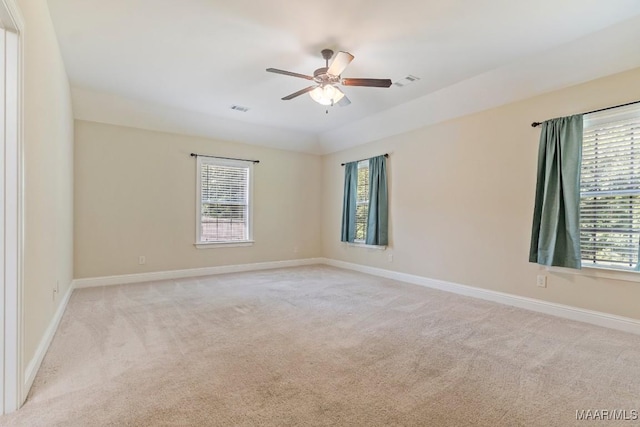 unfurnished room featuring ceiling fan, light carpet, and a wealth of natural light