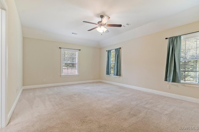 unfurnished room featuring light colored carpet, baseboards, a ceiling fan, and visible vents