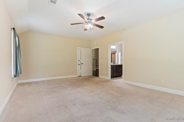 unfurnished bedroom with ensuite bath, a ceiling fan, visible vents, light carpet, and baseboards