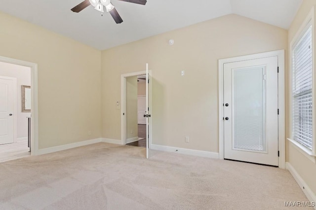 unfurnished bedroom with baseboards, ceiling fan, connected bathroom, vaulted ceiling, and light carpet
