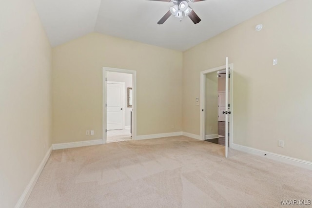 unfurnished bedroom with lofted ceiling, connected bathroom, light colored carpet, and ceiling fan