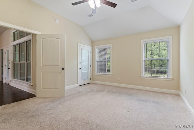 carpeted empty room with visible vents, baseboards, vaulted ceiling, and ceiling fan