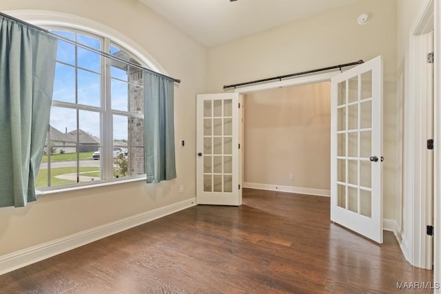 unfurnished room with french doors, baseboards, and wood finished floors