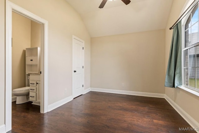 unfurnished bedroom with baseboards, dark wood-style flooring, multiple windows, and vaulted ceiling