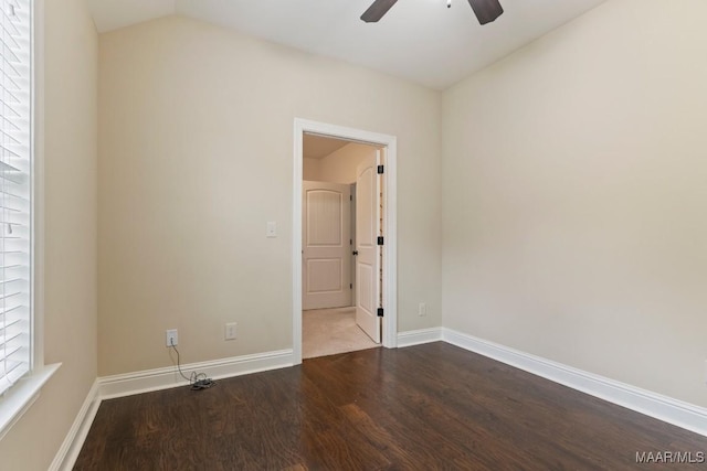 unfurnished room featuring lofted ceiling, baseboards, a ceiling fan, and dark wood finished floors