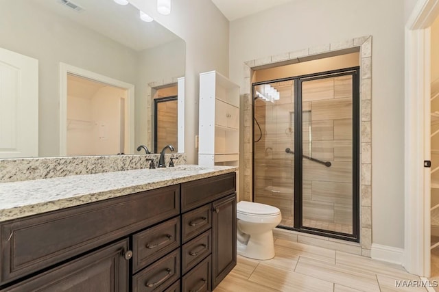 bathroom featuring vanity, toilet, and an enclosed shower