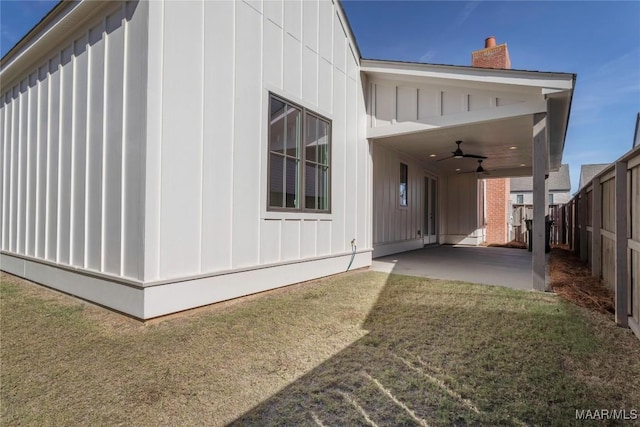 view of property exterior with a yard, a patio area, and ceiling fan