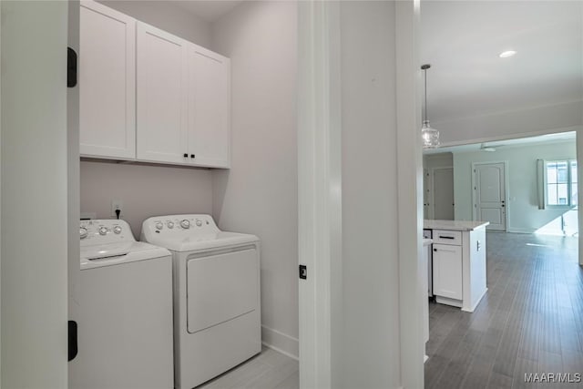 laundry area with independent washer and dryer, cabinets, and wood-type flooring