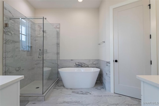 bathroom featuring vanity, separate shower and tub, and tile walls