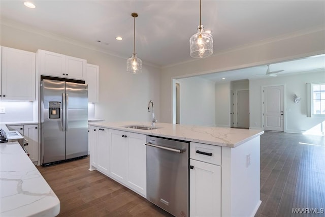 kitchen with stainless steel appliances, white cabinetry, a kitchen island with sink, and sink