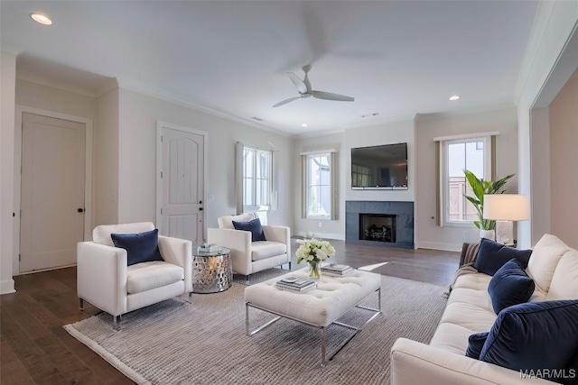 living room with crown molding, dark hardwood / wood-style floors, ceiling fan, and a fireplace