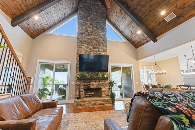 living room with an inviting chandelier, a wealth of natural light, hardwood / wood-style floors, and wooden ceiling