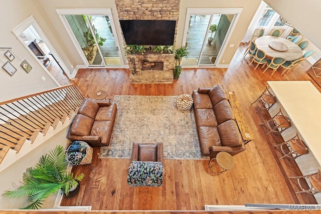 living room with a stone fireplace and hardwood / wood-style floors