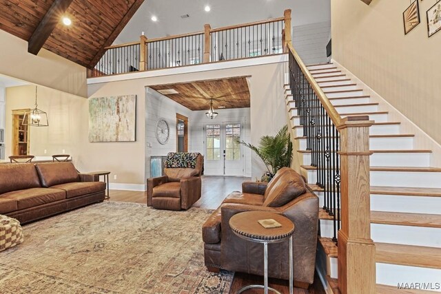 living room with high vaulted ceiling, wood-type flooring, a chandelier, wooden ceiling, and beam ceiling