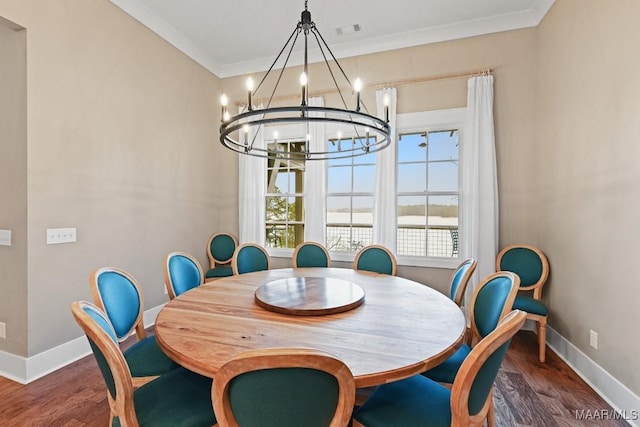 dining area featuring crown molding, dark hardwood / wood-style floors, and a notable chandelier