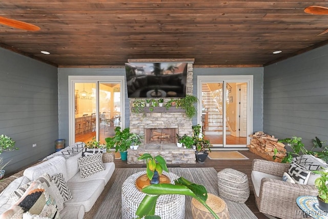 interior space featuring hardwood / wood-style flooring, wooden walls, wooden ceiling, and an outdoor stone fireplace