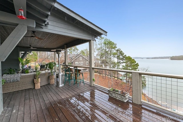 deck featuring a water view and ceiling fan