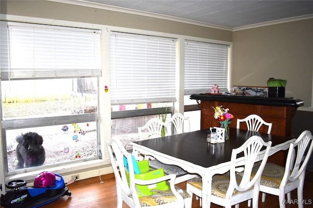 dining space with ornamental molding and hardwood / wood-style floors