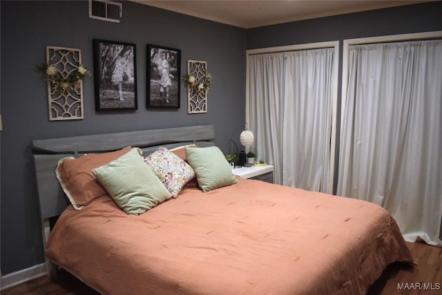 bedroom with hardwood / wood-style flooring and crown molding