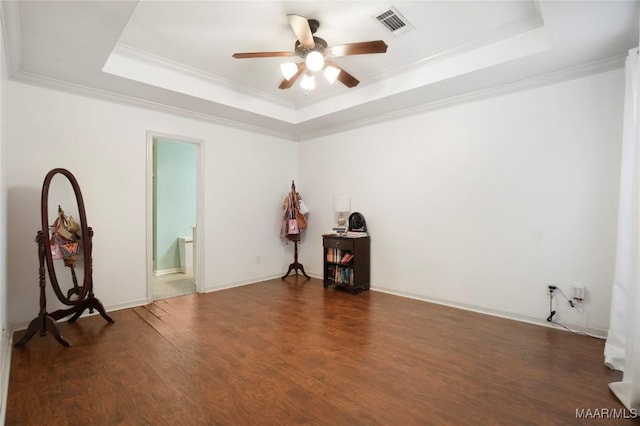 unfurnished room with dark hardwood / wood-style flooring, a tray ceiling, and crown molding