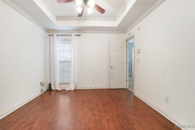 spare room featuring ceiling fan, ornamental molding, dark hardwood / wood-style flooring, and a raised ceiling