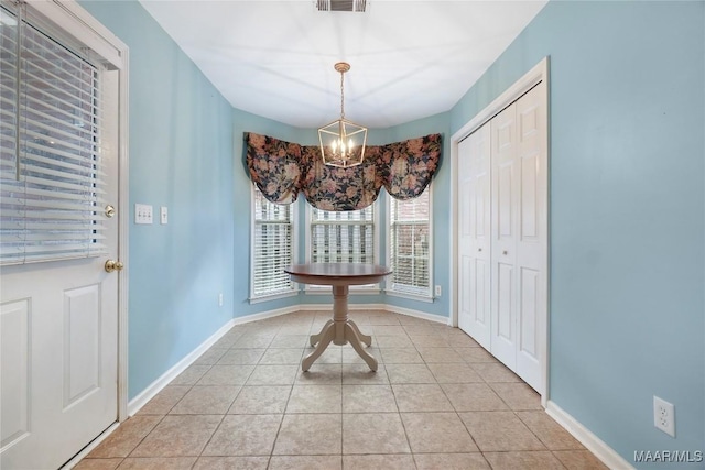 unfurnished dining area featuring an inviting chandelier and light tile patterned floors