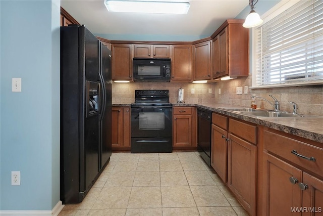 kitchen featuring tasteful backsplash, sink, black appliances, and hanging light fixtures