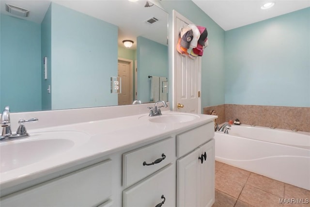 bathroom with tile patterned flooring, vanity, and a bath