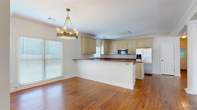 kitchen with crown molding, decorative light fixtures, wood-type flooring, and appliances with stainless steel finishes