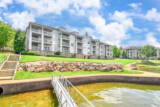 view of community featuring a water view and a yard