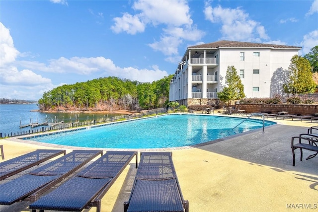 view of pool featuring a water view and a patio area