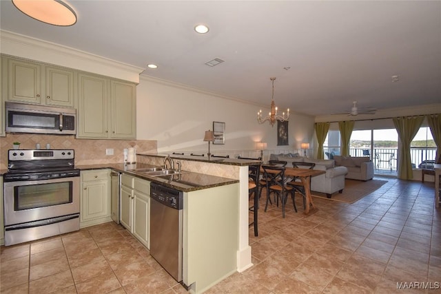 kitchen featuring sink, crown molding, stainless steel appliances, decorative backsplash, and kitchen peninsula