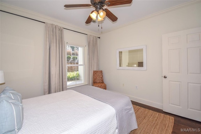 bedroom with dark hardwood / wood-style flooring, ornamental molding, and ceiling fan