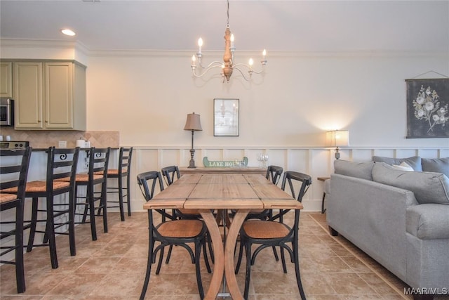 tiled dining area featuring crown molding and a chandelier