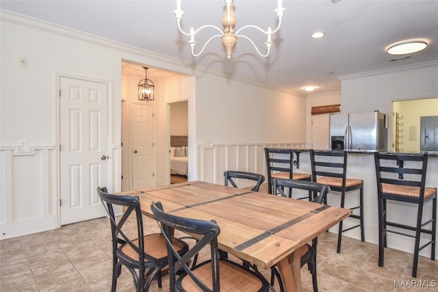 dining space with a notable chandelier, light tile patterned floors, and ornamental molding