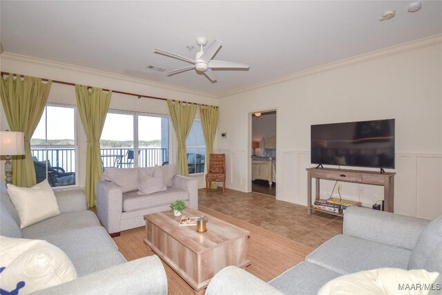 living room featuring crown molding, ceiling fan, and a water view