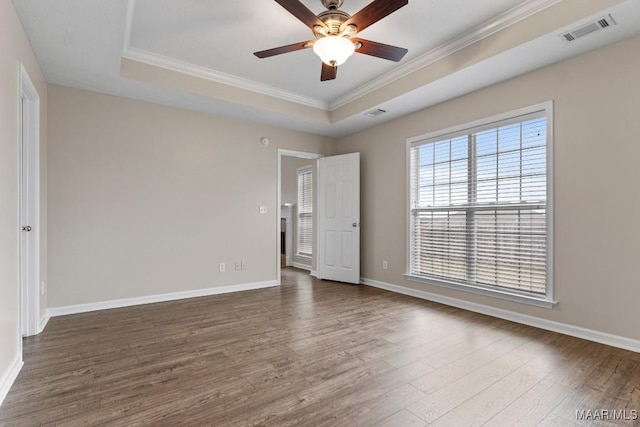 unfurnished bedroom with ceiling fan, ornamental molding, dark hardwood / wood-style floors, and a raised ceiling