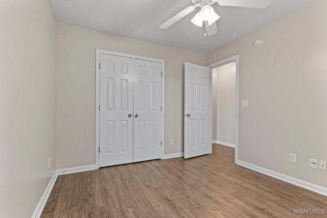 unfurnished bedroom featuring ceiling fan, light hardwood / wood-style floors, and a closet