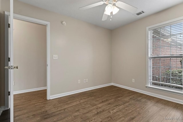 spare room featuring dark wood-type flooring and ceiling fan