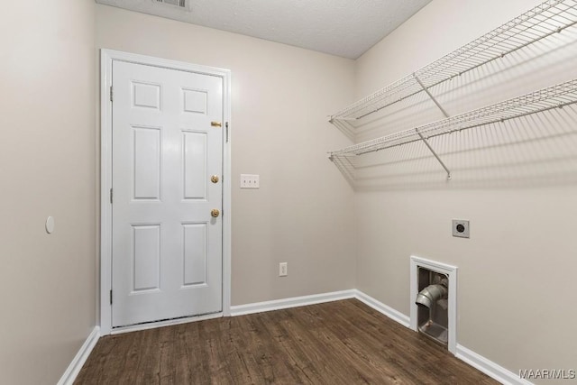 clothes washing area with dark hardwood / wood-style floors, hookup for an electric dryer, and a textured ceiling