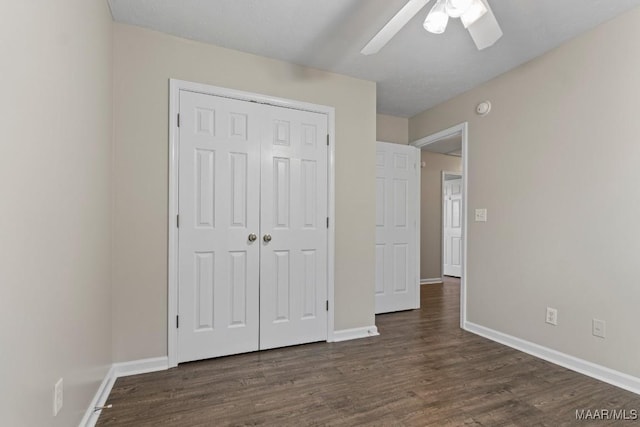 unfurnished bedroom featuring dark wood-type flooring, ceiling fan, and a closet